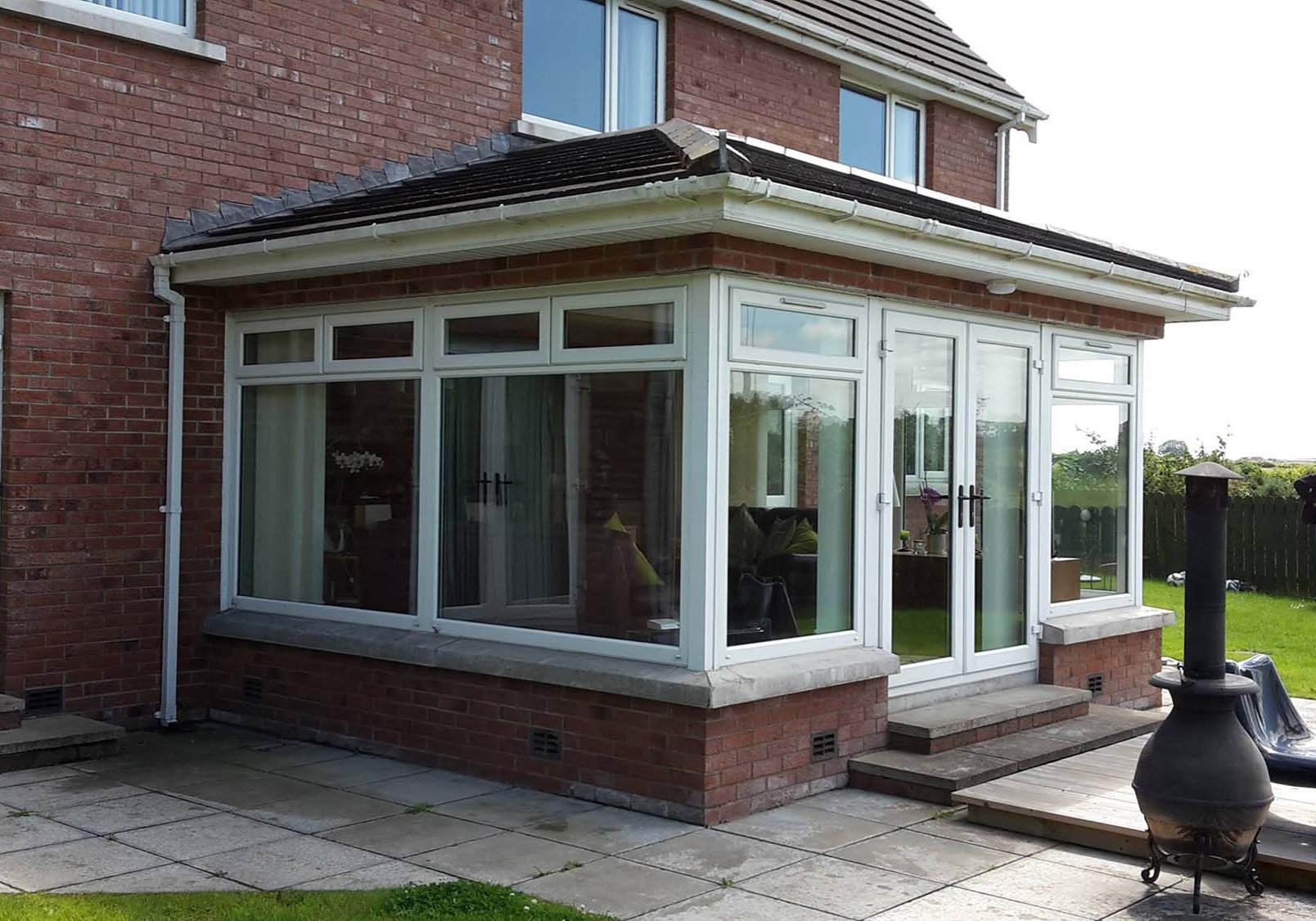 Newly built extension at the back of the house with garden furniture and a log burner