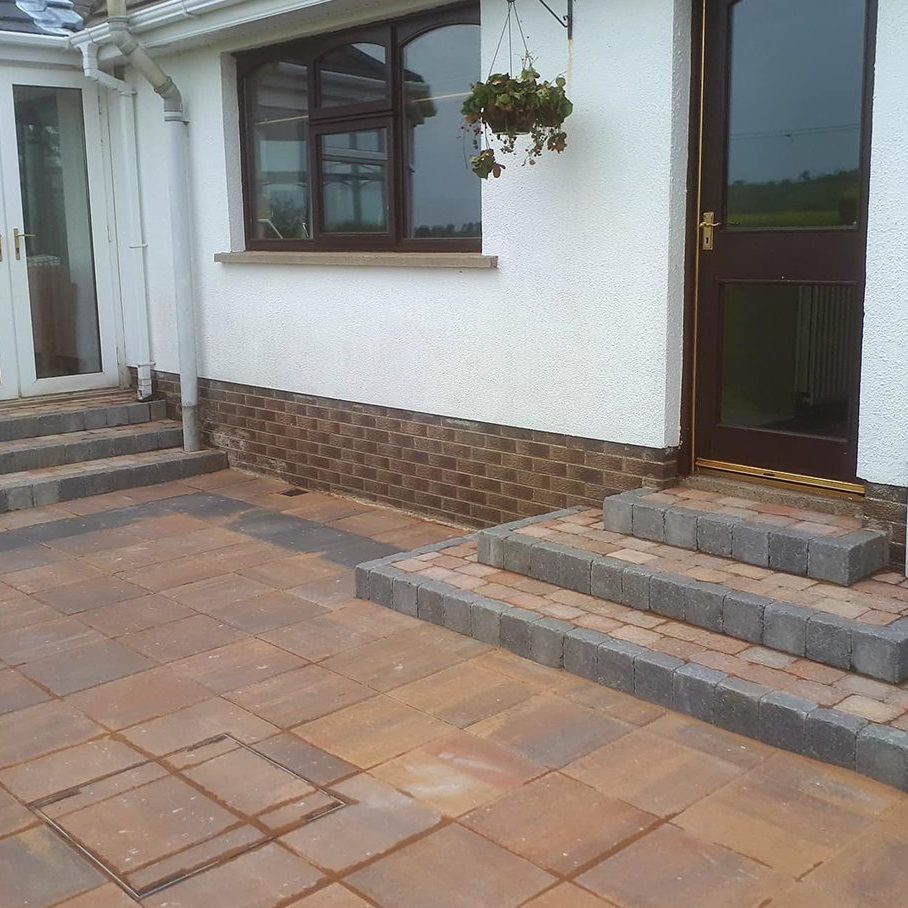 Newly laid paving stones with steps leading to the doors of the house