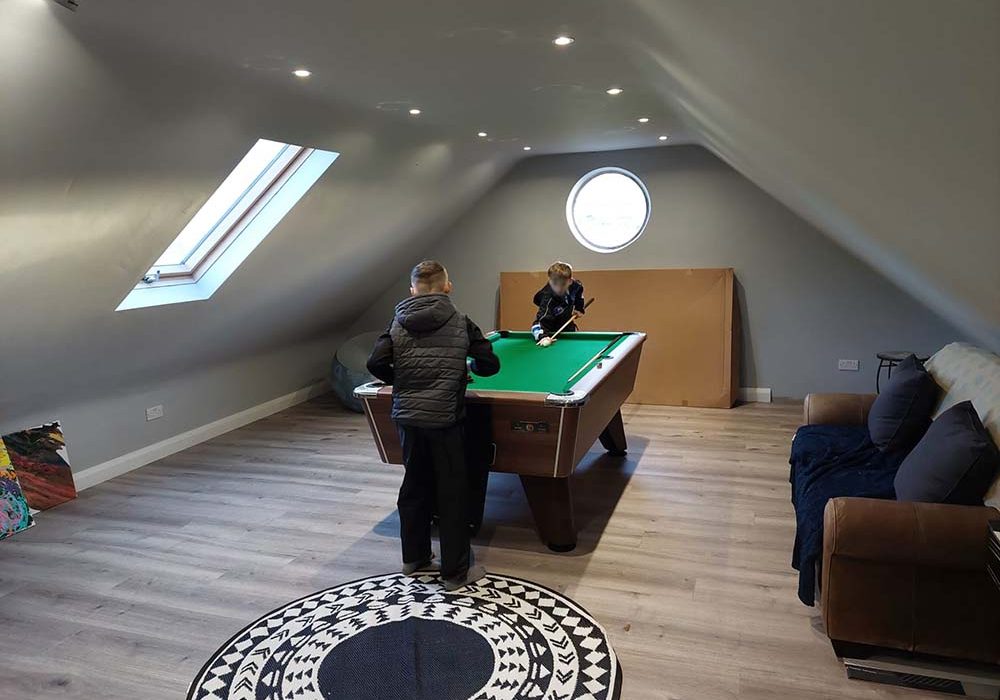 Loft conversion with two children playing pool